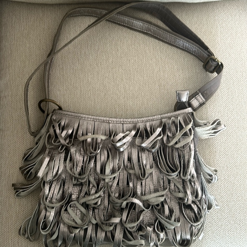 Fun midsize hobo bag in silver. Each side has a different design.. no tears